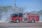 Firemen fighting roadside fire in summer