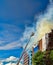 Firemen on a ladder extinguishing fire