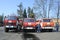 Firemen standing near fire trucks before training