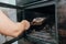 Fireplace cleaning. A woman\'s hand holds a shovel with ash in a burnt-out fireplace. Close up view