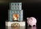 Fireplace with firewood and piggy bank on black background. Heating is getting more expensive. Firewood price. Energy