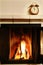 Fireplace and old-fashioned copper alarm clock on the mantelshe