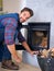 Fireplace, wood and portrait of man with fire for heat, warmth and light in winter in home. Flame, burning and person