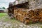 Firewood cut and stacked on the street in a medieval looking street.