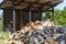 Firewood harvested for heating in winter. A pile of firewood in the courtyard of the house on the green grass