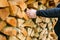 Firewood and mens hands close-up. solid fuel.Male hands pulling a log from a woodshed. Heating season.Heating season