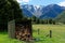 A firewood shed stocked with firewood, snow capped mountains in the background