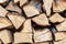 Firewood stack wall. Stack of wood prepared for winter and cold weather. Dry chopped oak wood. Wooden background texture