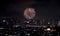 Firework bursting above dark city in night.