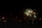 Fireworks display against buildings and dark sky in the city on New Year\\\'s Eve