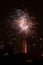 Fireworks display against buildings and dark sky in the city on New Year\\\'s Eve