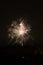 Fireworks display against buildings and dark sky in the city on New Year\\\'s Eve