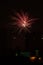 Fireworks display against buildings and dark sky in the city on New Year\\\'s Eve