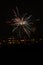 Fireworks display against buildings and dark sky in the city on New Year\\\'s Eve