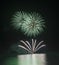 Fireworks display over sea with reflections in water