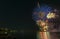 Fireworks over the ocean in the big city, silhouettes of people