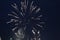 Fireworks salute white flashes lights rose white on a dark black background. Festive atmosphere New Year Christmas Independence