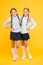 Firm friends. School girls with plaited hair in long braids. Cute little girls smiling on yellow background. Happy small
