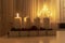 First advent light, four white candles on table with electic advent candlestick on background, the christmas period