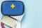 First aid kit on blue background with copy space, medications, pain relievers, antibiotics, vitamins, antidepressants, antivirals