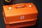 First aid kit, orange container with a cross. Portable basic first aid equipment for lifeguards for sporting events on