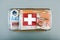 First aid kit packed with medical supplies on grey background