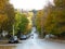 First autumn fall days in a small town. Green yellow trees in the street.