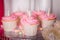 First baby girl birthday party concept. Candy bar with sweet unicorn cakes and decor items in bright pink colors.