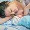 The first breast feeding of a newborn baby boy immediately after giving birth on a hospital bed in a maternity ward