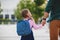 First day at school. father leads little child school girl in f