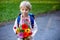 First day at school for a firstgraden, child starting school, bringing flowers for the teacher, family going with him