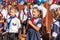 First-form schoolgirl at school on holiday of beginning of elementary education reading poetry. Girl with microphone declaiming