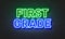 First grade neon sign on brick wall background.