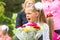 First grader with bouquet of flowers yawns at school in a crowd