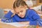 First grader at reading lesson reading text sitting at a school desk