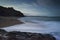 First light at Porthleven beach with the waves breaking at the shore