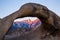 First light of the sunrise on Mount Whitney looking through Mobius Arch in the Alabama Hills