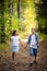 First love. Little boy and girl holding hands and smiling while walking outdoors in park