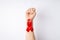 First person top view photo of raised female hand with clenched fist and red ribbon on wrist symbol of aids awareness on 