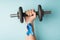 First person top view photo of raised man`s hand holding dumbbell and blue ribbon on wrist symbol of prostate cancer awareness on