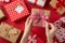 First person top view photo of saint valentine`s day decorations young woman`s hands untying checkered ribbon bow on kraft paper