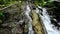 First-person video of a jungle to a cliff on a high mountain with a rock river