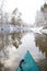 A first person view from a canoe paddling along the river in winter