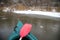 A first person view from a canoe paddling along the river in winter