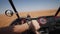 First person view of driving sand buggy in the desert. Woman driving an offroad vehicle on sand dunes