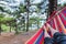 First-person view of the feet in a hammock in the forest. The concept of outdoor recreation