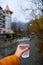 First-person view holding a glass of pure water from a mountain spring against the background of the city of Borjomi