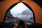 first person view of a person resting inside a camping tent on the mountain, point of view of a hiker man, traveler woman at the