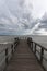 First person view of a pier on a lake on a moody day, with dark