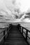 First person view of a pier on a lake on a moody day, with dark